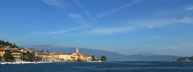 Trip Kroatien beliebte Urlaubsziele am Gardasee -  Mit einer Fläche von 370 km² ist der Gardasee der größte See Italiens. Es liegt am Fuße der Alpen und erstreckt sich über drei Staaten: Lombardei, Venetien und Trentino. Die maximale Tiefe des Sees beträgt 346 m, er hat eine längliche Form und sein nördliches Ende ist sehr schmal. Dort ist der See von den Bergen der Gruppo di Baldo umgeben. Du trittst aus deinem gemütlichen Hotelzimmer und es begrüßt dich die warme italienische Sonne. Du blickst auf den atemberaubenden Gardasee, der in zahlreichen Blautönen schimmert - von tiefem Dunkelblau bis zu funkelndem Türkis. Majestätische Berge umgeben dich, während die Brise sanft deine Haut streichelt und der Duft von blühenden Zitronenbäumen deine Nase kitzelt. Du schlenderst die malerischen, engen Gassen entlang, vorbei an farbenfrohen, blumengeschmückten Häusern. Vereinzelt unterbricht das fröhliche Lachen der Einheimischen die friedvolle Stille. Du fühlst dich wie in einem Traum, der nicht enden will. Jeder Schritt führt dich zu neuen Entdeckungen und Abenteuern. Du probierst die köstliche italienische Küche mit ihren frischen Zutaten und verführerischen Aromen. Die Sonne geht langsam unter und taucht den Himmel in ein leuchtendes Orange-rot - ein spektakulärer Anblick.